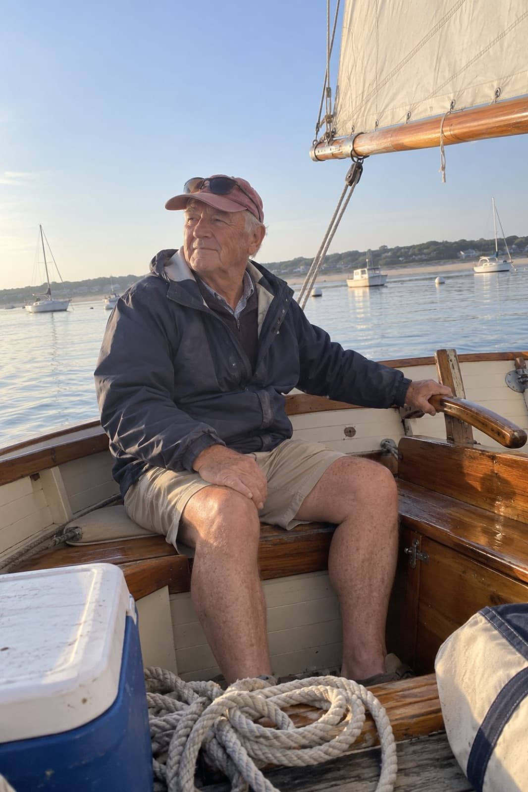 Tom at the tiller of his wooden catboat in Wellfleet harbour